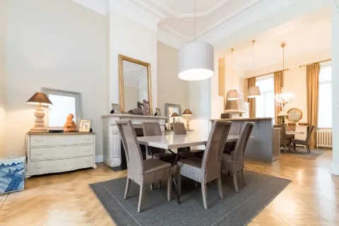Salle à manger lumineuse avec grande table en bois.