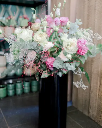 Bouquet de roses blanches et roses dans un vase noir