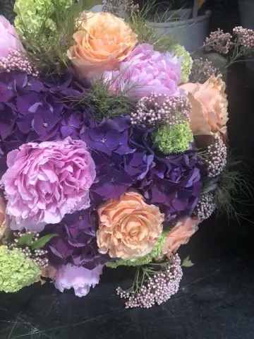 Bouquet d’hortensias mauves, de roses pêche et de fleurs vertes