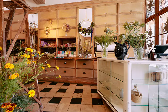 Toonbank van het atelier van Versus met vazen vol verse bloemen