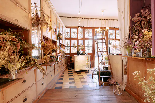 Installatie van hangende gedroogde bloemen boven de authentieke toonbanken van de winkel