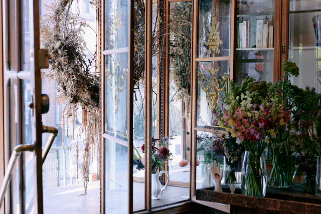 Etalage van de winkel met verse boeketten en hangende gedroogde bloemen
